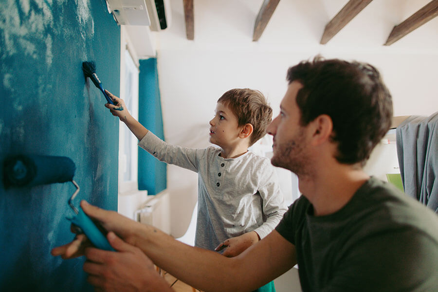 father and son painting a wall in home