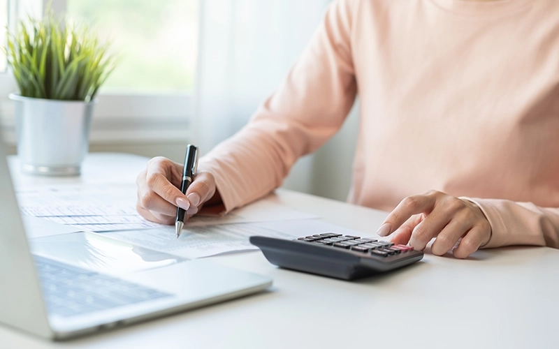 woman on laptop with calculator