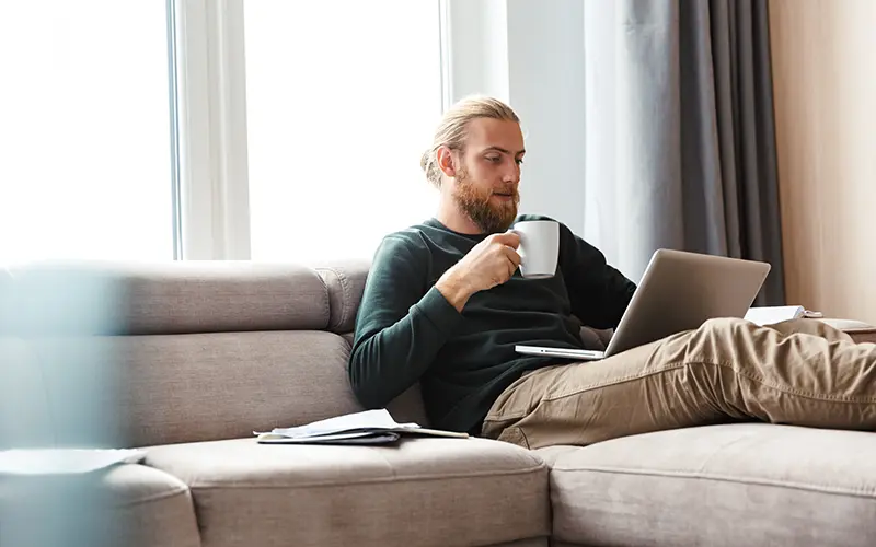 man on sofa with laptop