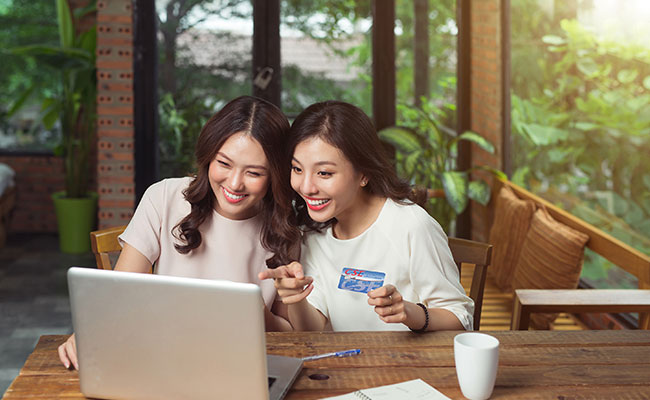 two girls using their CSE Visa to pay for items online