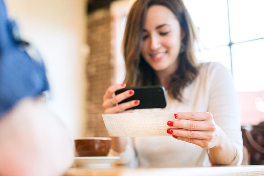 young woman depositing check on phone