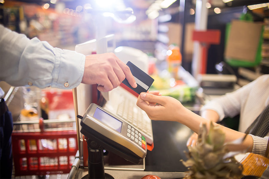 person using card to pay for groceries